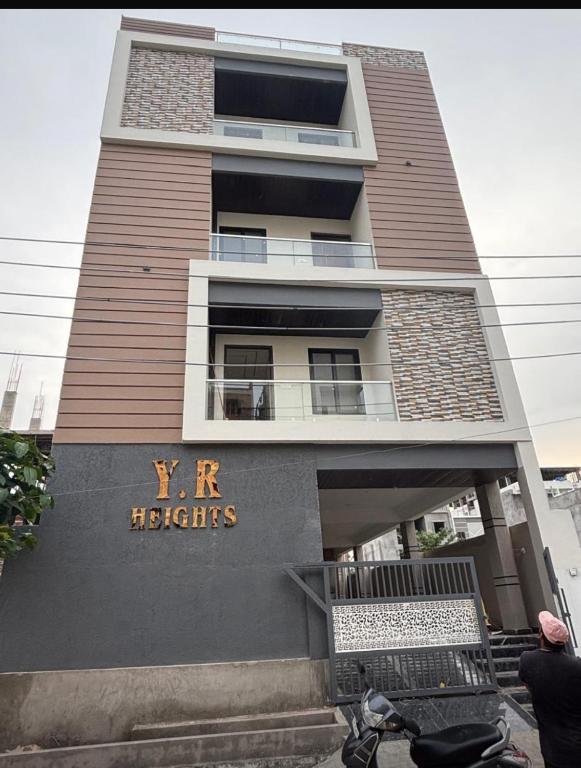 a tall building with a sign that reads xr heights at Heaven hub in Haidar Sāhibgūda