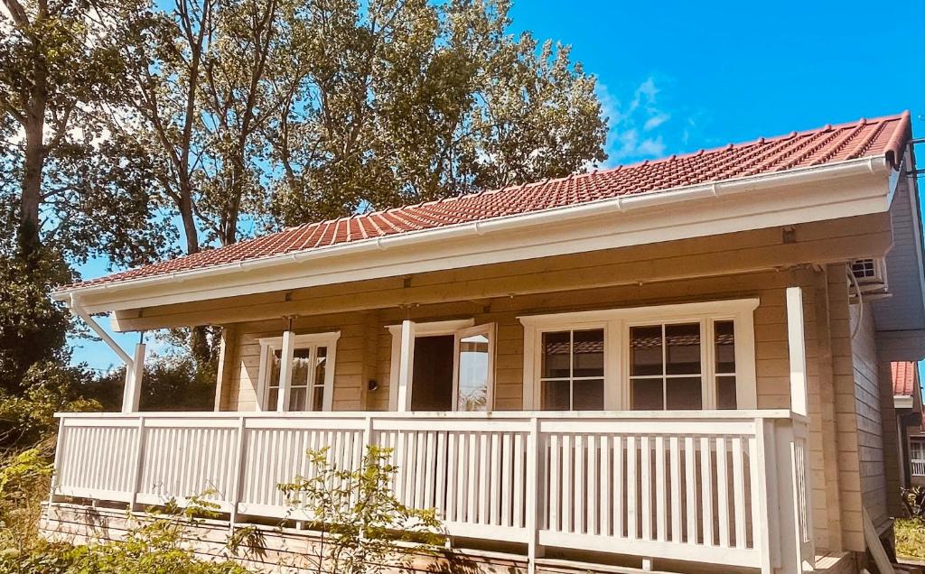 ein kleines Haus mit einem weißen Zaun in der Unterkunft Cottage scandinave 89 in Bourbourg