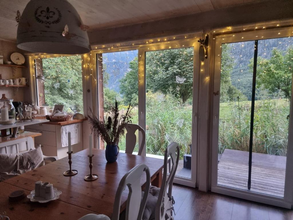 Un comedor con una mesa y una gran puerta corrediza de vidrio. en Countryhouse Lake Attersee - Traumhaft schöne Lage - Bezauberndes Hideaway, en Unterach am Attersee