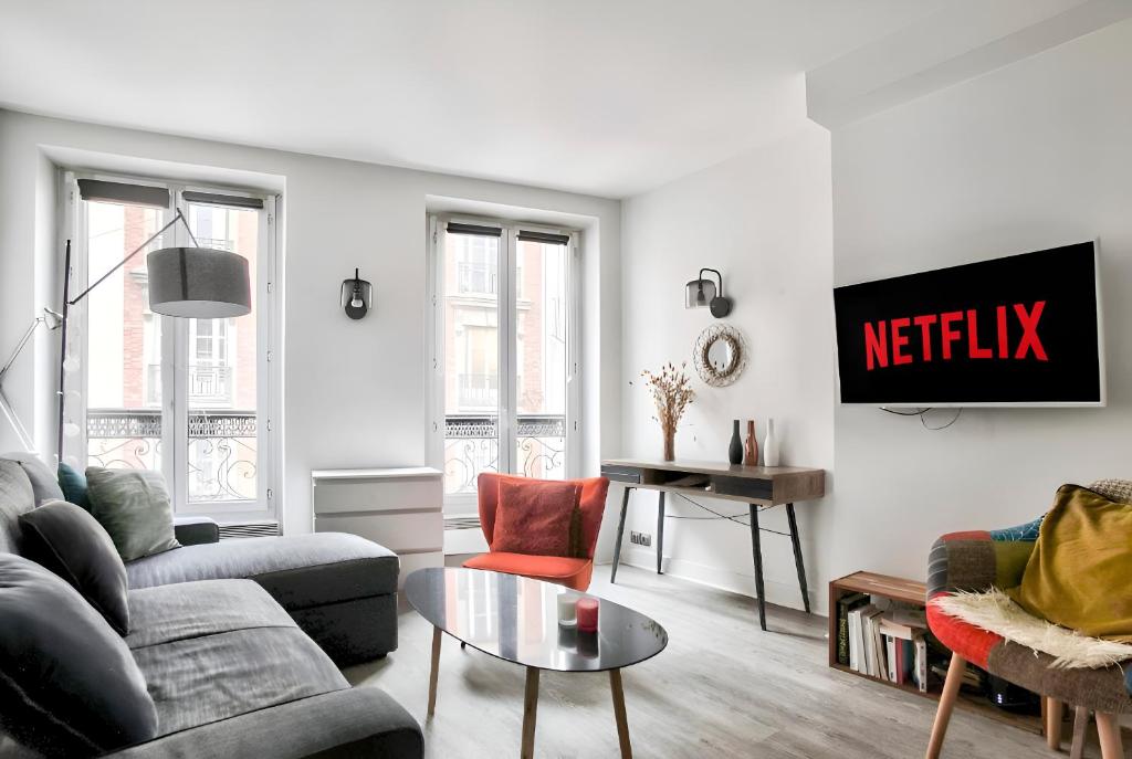 un salon avec un canapé et une table dans l'établissement Appartement Quartier Tour Eiffel Free Netflix, à Paris