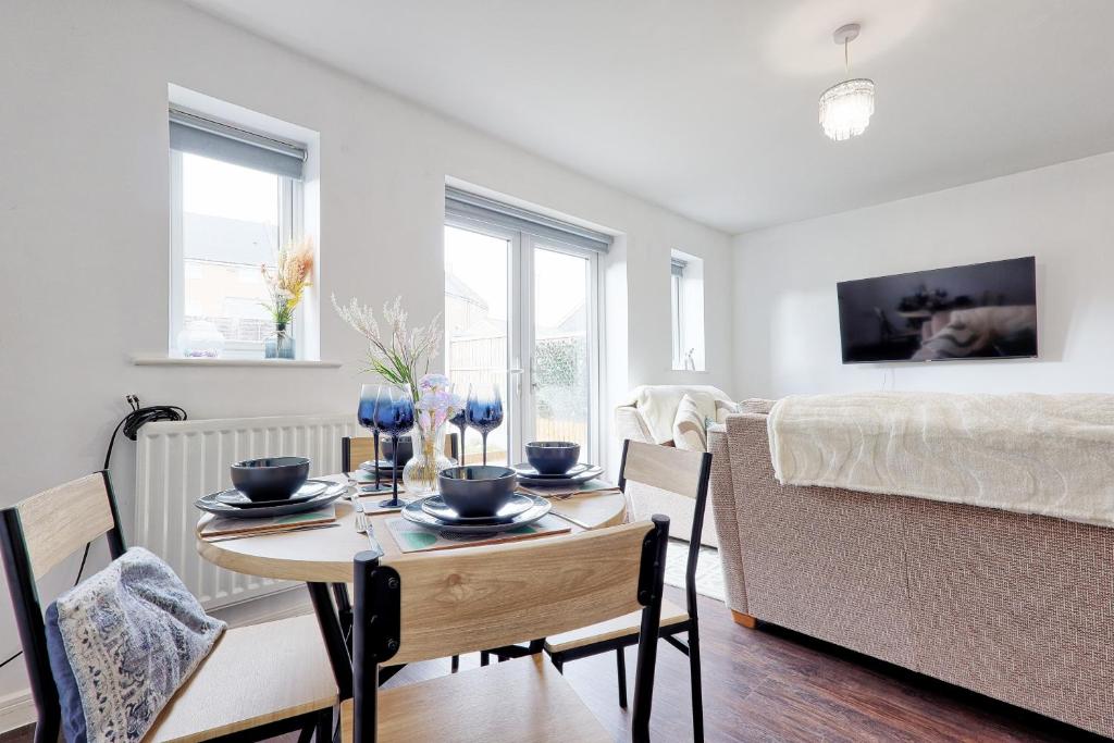 a dining room with a table and chairs and a bed at Modern 3-Bed 3-Bath Home - Quiet Road - Parking For 2 Cars - LMV Property in Great Burstead