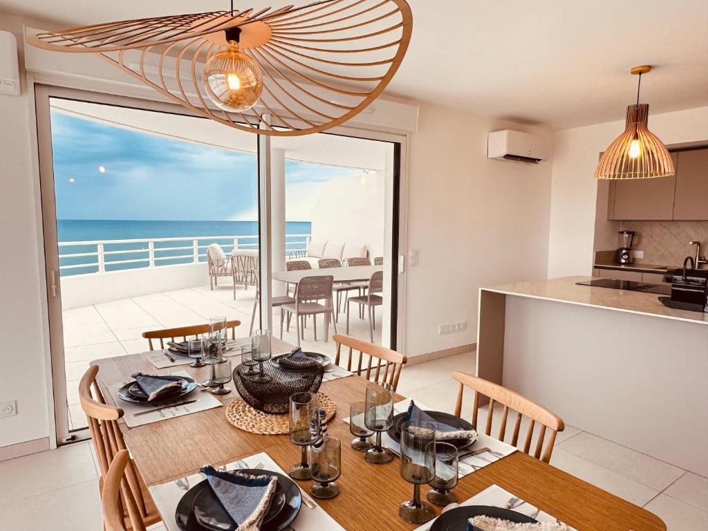 a kitchen and dining room with a table and a view of the ocean at ValrasLoc Archipel Panarea Vues Inegalees in Valras-Plage