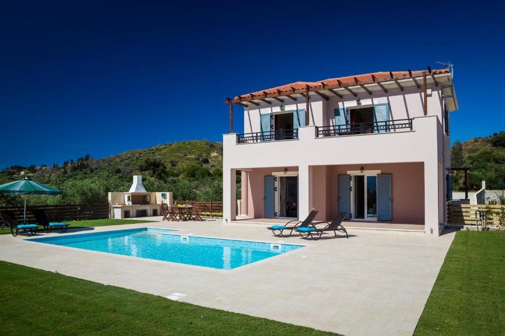 une villa avec une piscine en face d'une maison dans l'établissement Armonia Villas, à Lixouri