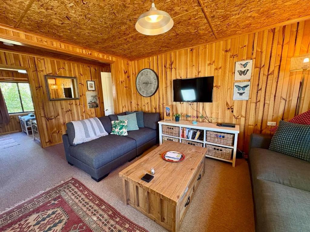 a living room with a couch and a coffee table at Briar Cottage Weldborough in Weldborough