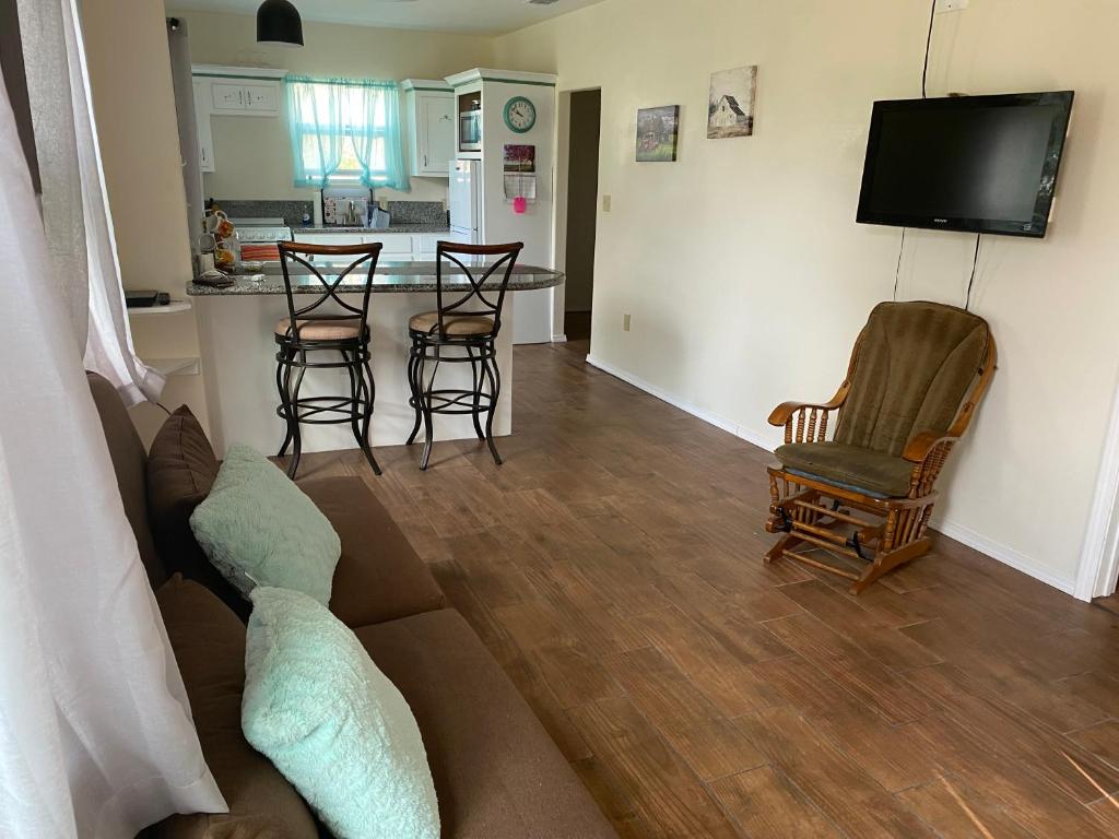 a living room with a couch and chairs and a kitchen at Country Home close to Town in Harlingen