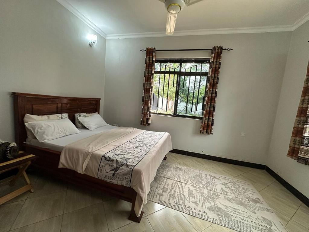 een slaapkamer met een groot bed en een raam bij Apartment 72 in Moshi