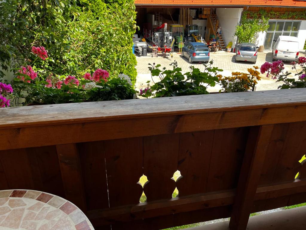 a wooden fence with a table and a chair at FeWo Feil nord in Freilassing