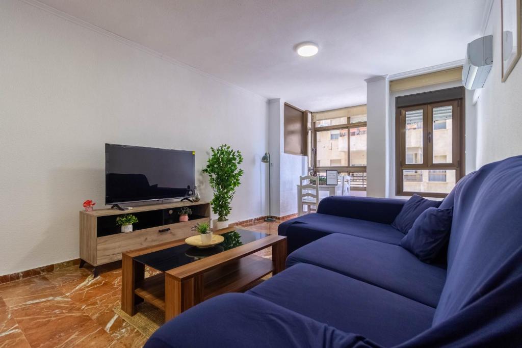 salon z niebieską kanapą i telewizorem w obiekcie Piso Museo del Realismo-Catedral-Alcazaba-Free Parking-Wifi-Aire acondicionado w mieście Almería