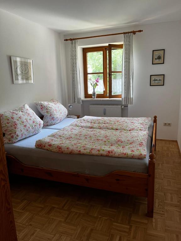 a bed in a bedroom with a window and a bedspread at FeWo Feil süd in Freilassing