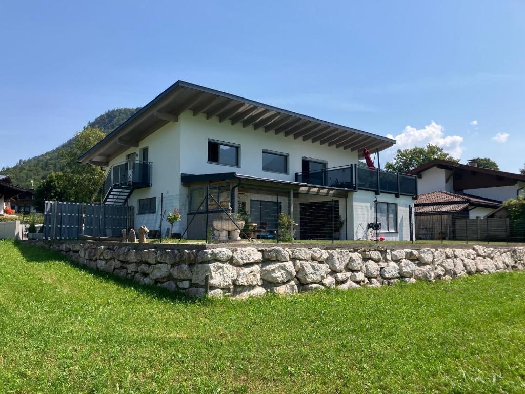 a house with a stone wall in the grass at Tanja's Kaiserdomizil in Walchsee