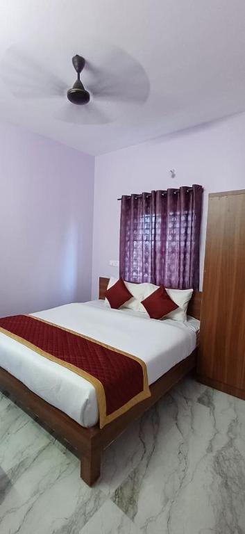a bedroom with a large bed with red pillows at BANGALOUR ELITE Residency Attibele in Bangalore