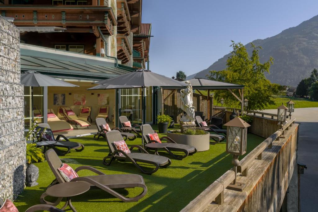 a group of chairs and umbrellas on a lawn at Wohlfühlhotel KERSCHDORFER - B&B - ADULTS ONLY in Kaltenbach