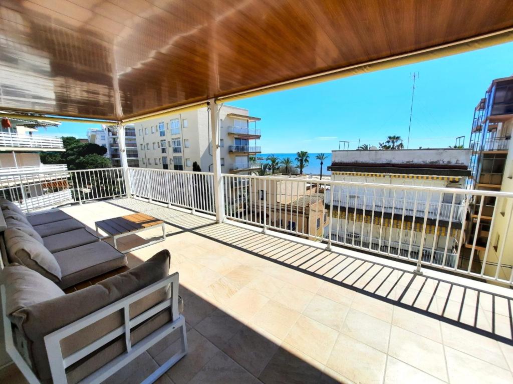 a balcony with a couch and a large window at Apartment Del Sol with SEA views in Salou