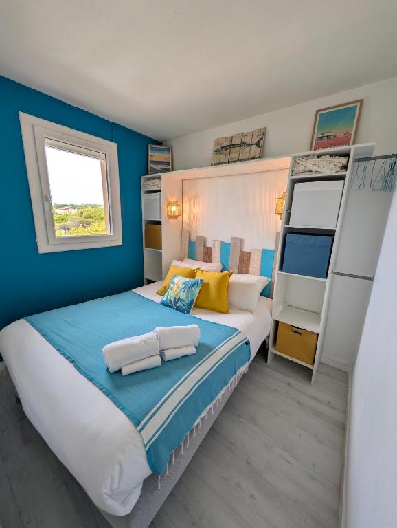 a bedroom with a king sized bed with blue walls at appartement T2 biscarosse plage in Biscarrosse-Plage