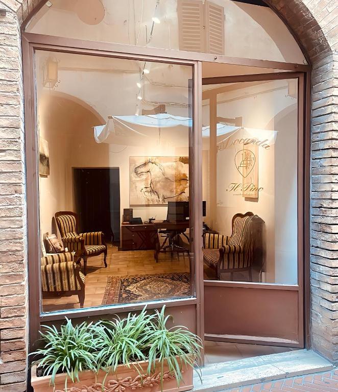 een weerspiegeling van een woonkamer met stoelen en een tafel bij Locanda Il Pino in San Gimignano