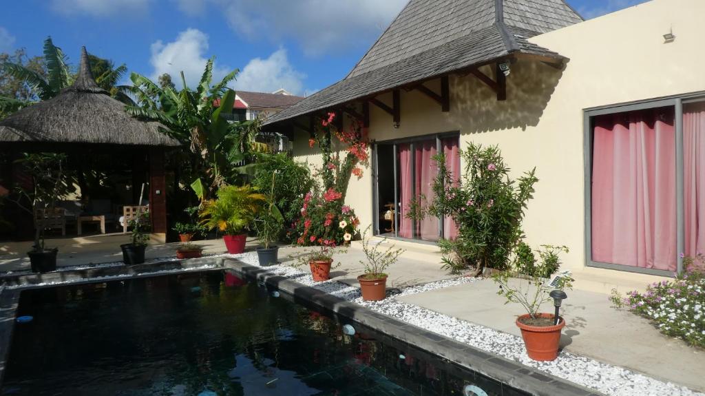 a villa with a swimming pool in front of a house at Studio le Dauphiln du Lagon Bleu - Grand Baie in Grand Baie