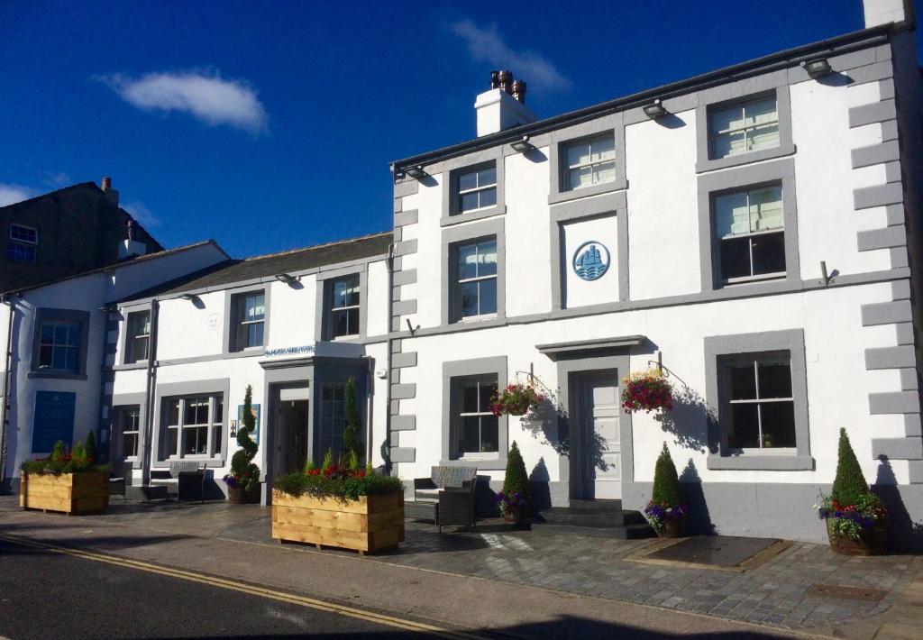 a white building with potted plants in front of it at The Morecambe Hotel in Morecambe