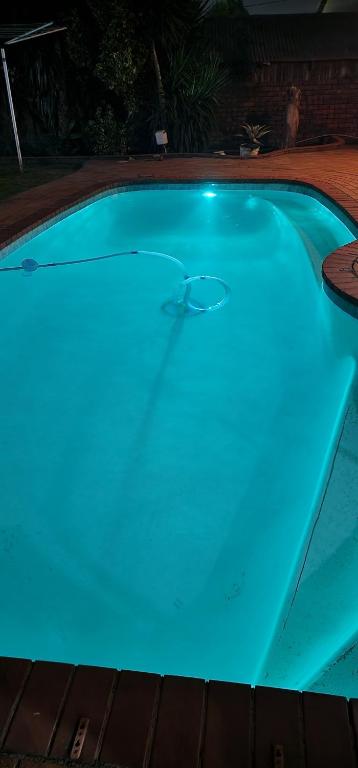 a swimming pool with blue lighting in a backyard at La' Romi Self Catering Units in Pietermaritzburg