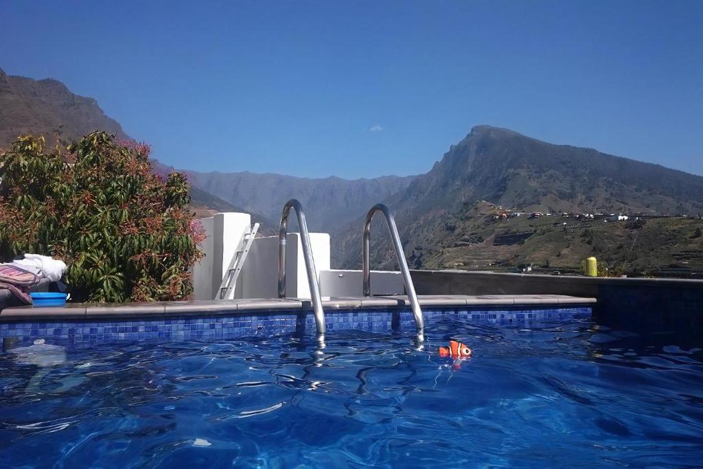 una piscina con 2 cargueros en el agua con montañas en Casa Vista Caldera, en Tijarafe