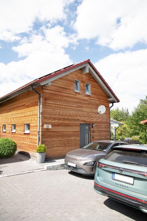 a wooden building with a car parked in front of it at Overkamps - das Ferienhaus Odernheim in Odernheim