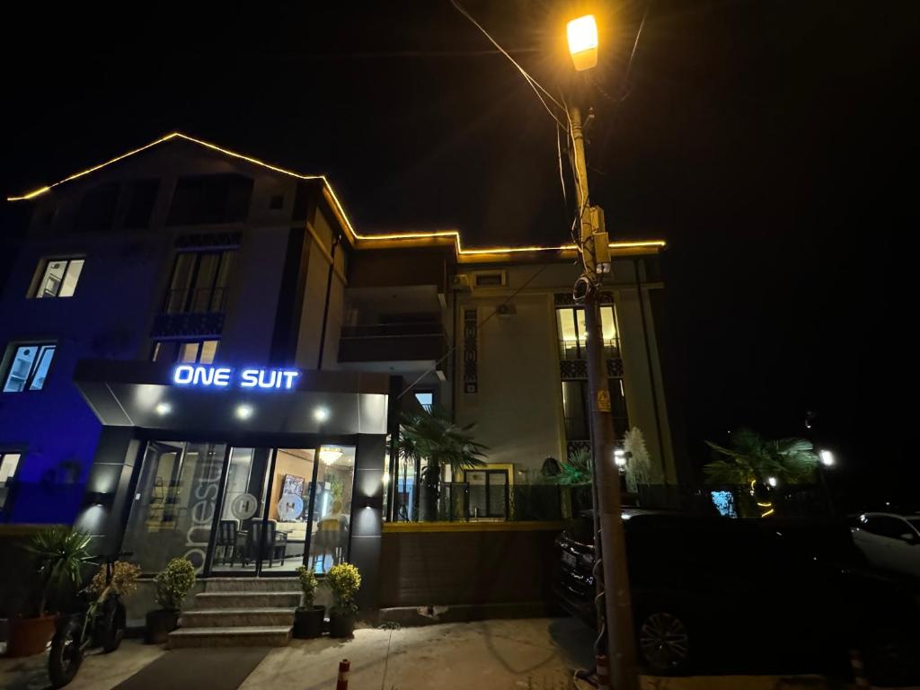 a building with a lit up sign in the night at One Suit in Kartepe