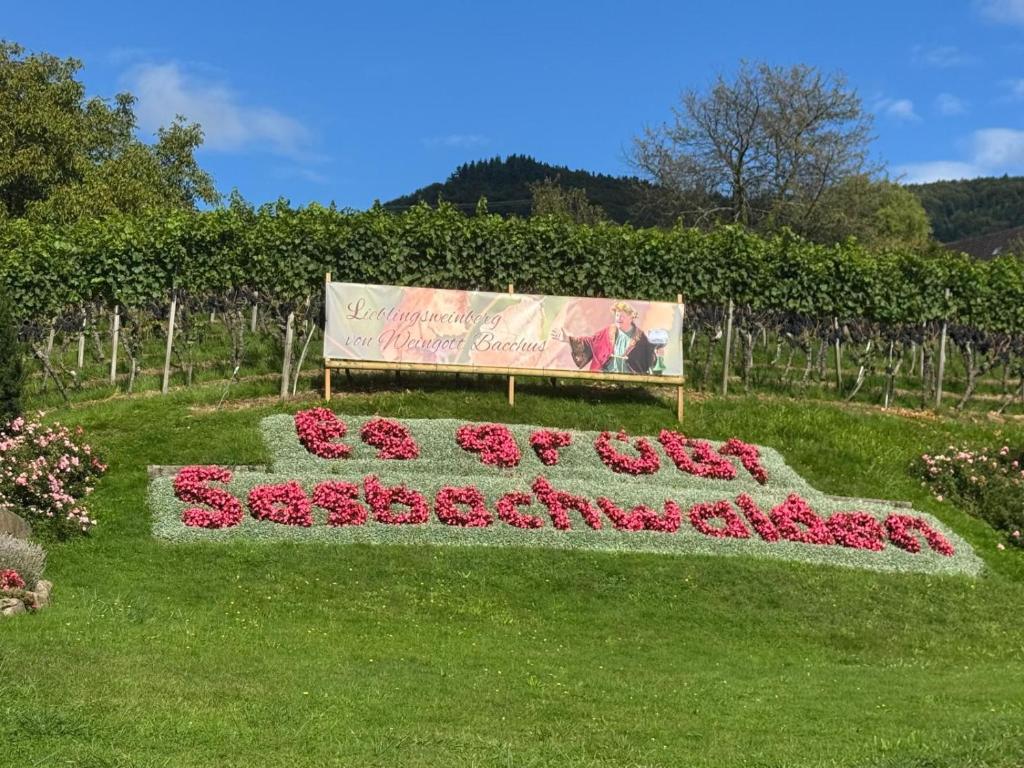 a sign for a garden with flowers in the grass at Schwarzwaldloge Zeitlos in Brandmatt