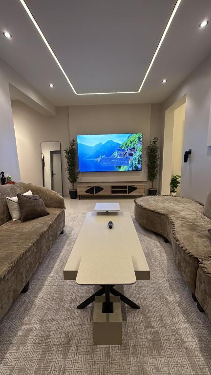 ein Wohnzimmer mit zwei Sofas und einem Flachbildfernseher in der Unterkunft شقة الراحة in Tabuk
