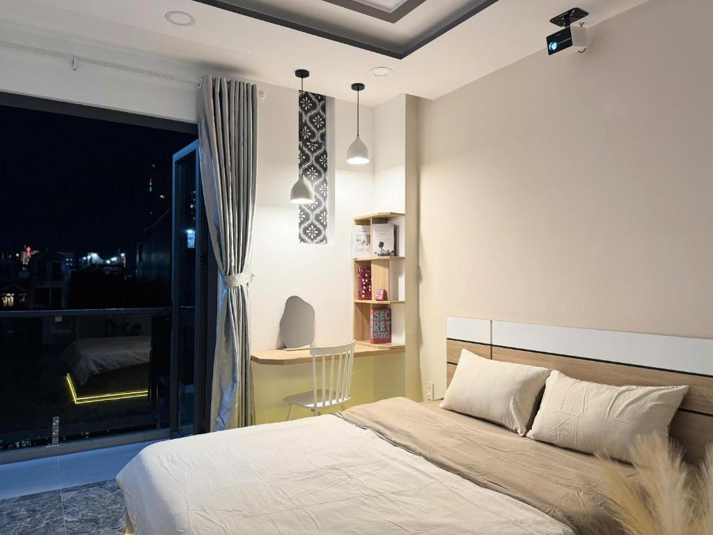 Un dormitorio con una cama y un escritorio y una ventana. en Four P Home Phu Nhuan, en Ho Chi Minh