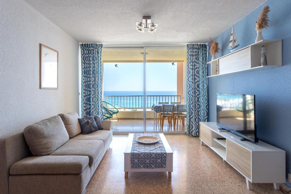 Una sala de estar con un sofá y un televisor de pantalla plana. en Paradise View, en Villajoyosa