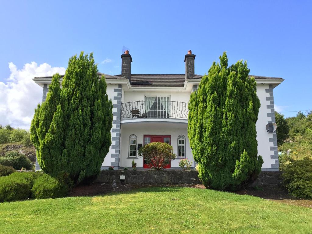 a white house with trees in front of it at The Lodge B&B in Galway