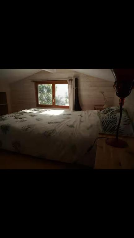 a bedroom with a bed and a window at Cabane en bois in Saint-Antonin-Noble-Val