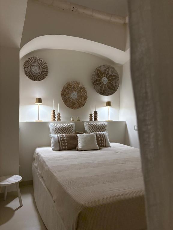 een slaapkamer met een groot bed met kussens erop bij PugliAlcove in Castellana Grotte