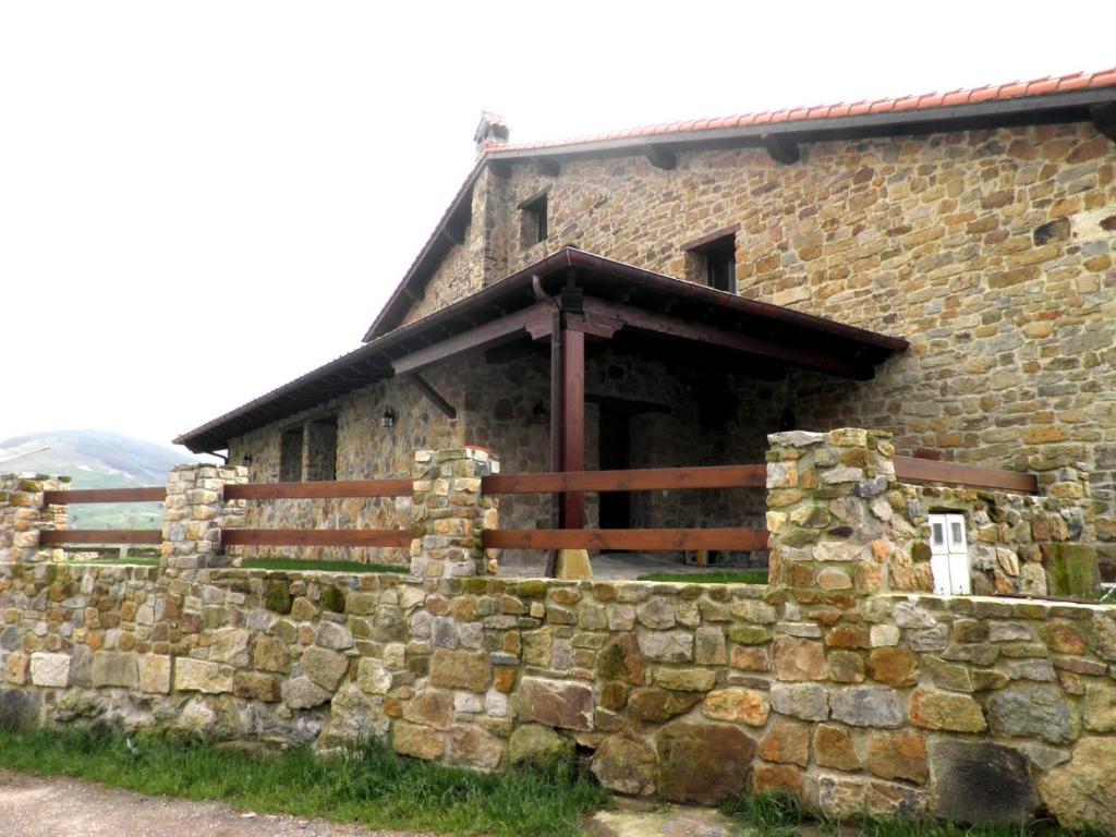 an old stone house with a stone wall at Casa Rural La Charruca in Abionzo