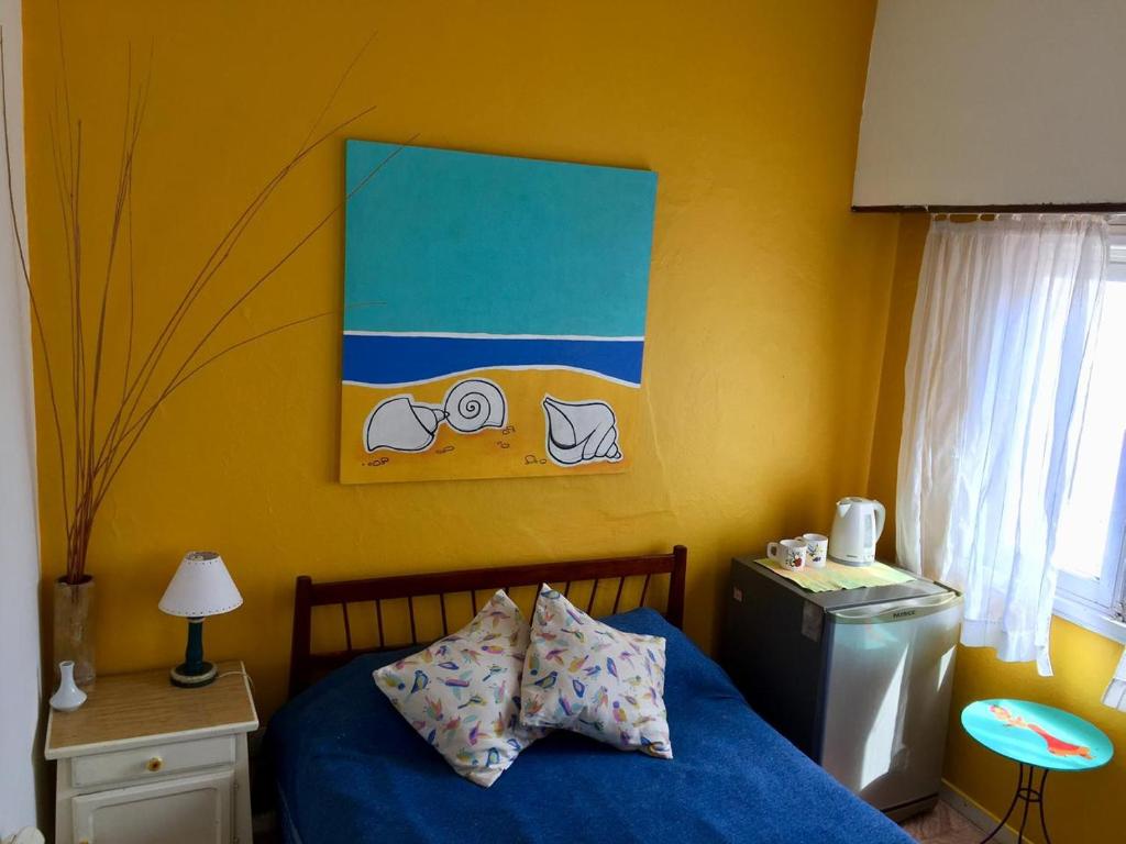 a bedroom with a blue bed and a painting on the wall at La Vecindad del Sol Depto H in Miramar
