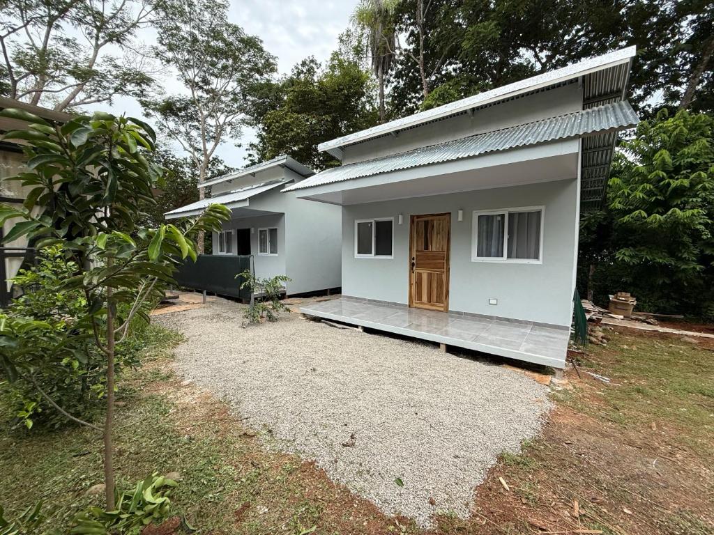 a small white house with a door in a yard at Villa Carpintera in Puntarenas