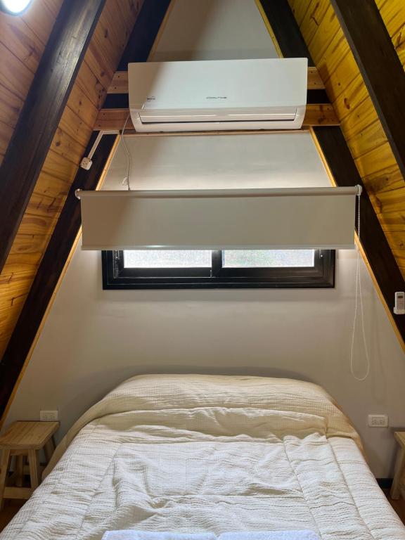 una camera con un letto in una casetta di Aire Escondido a Villa Berna