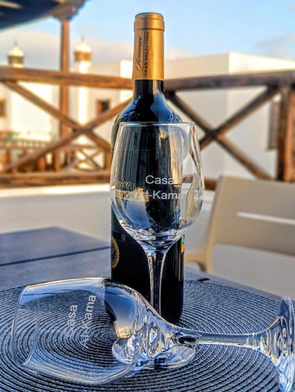a bottle of wine and a glass on a table at Casa Alkama in Playa Honda