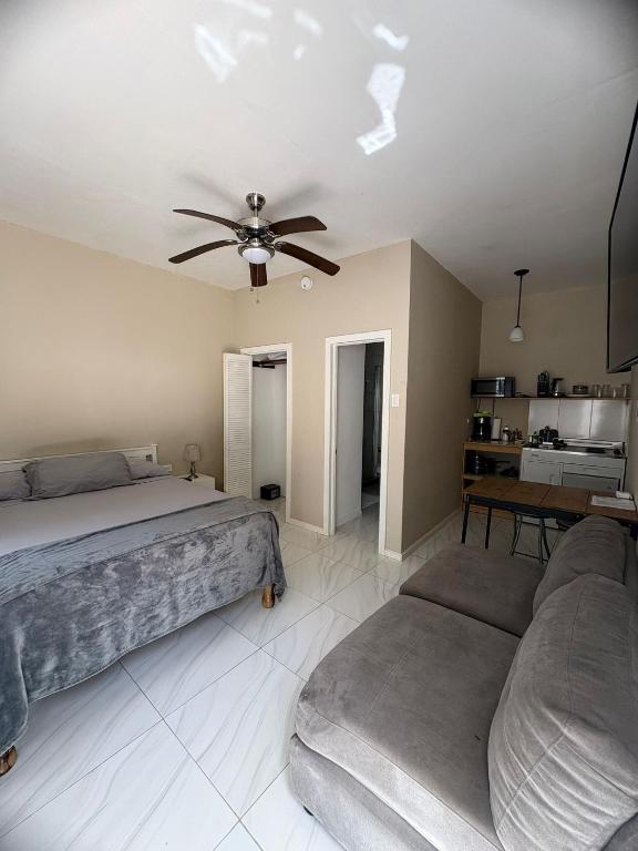 a bedroom with two beds and a ceiling fan at Finn Room - Ferdie's Place in Port Antonio