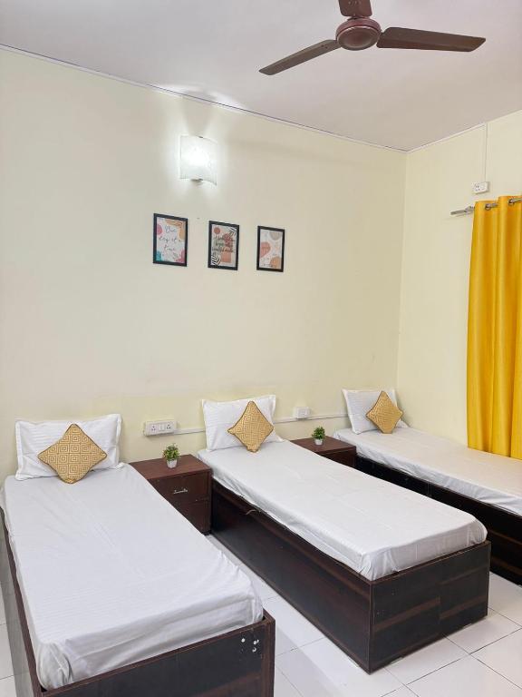een kamer met twee bedden en een plafondventilator bij Elite Hostel- A Perfect Stay for Working Professional,Travellers in Pune