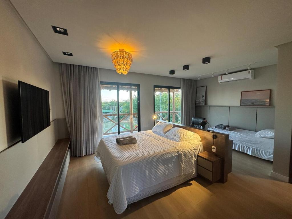 a large bedroom with a bed and a chandelier at Casa Aloha in Petrolina