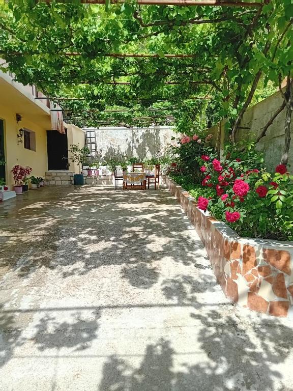 a patio with a table and flowers in a yard at Villa Gimi in Gjirokastër
