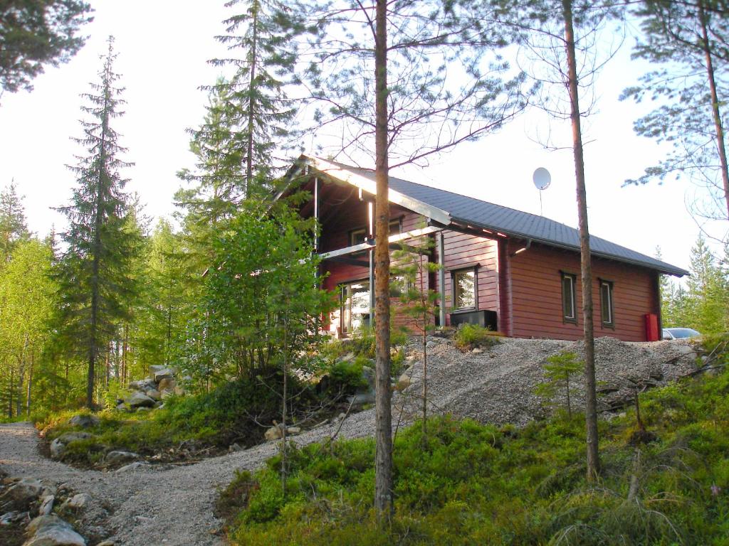 a log cabin in the woods with a gravel driveway at Heart of silence 