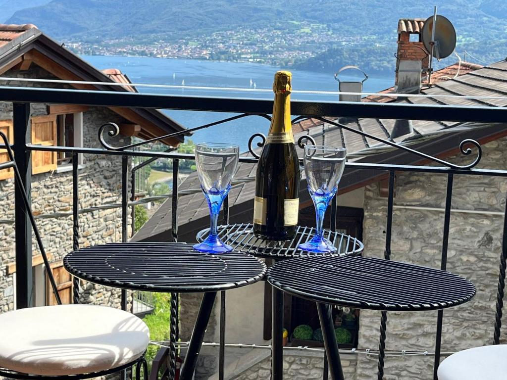 a bottle of wine and two glasses on a table at La casa sul lago blu in Domaso