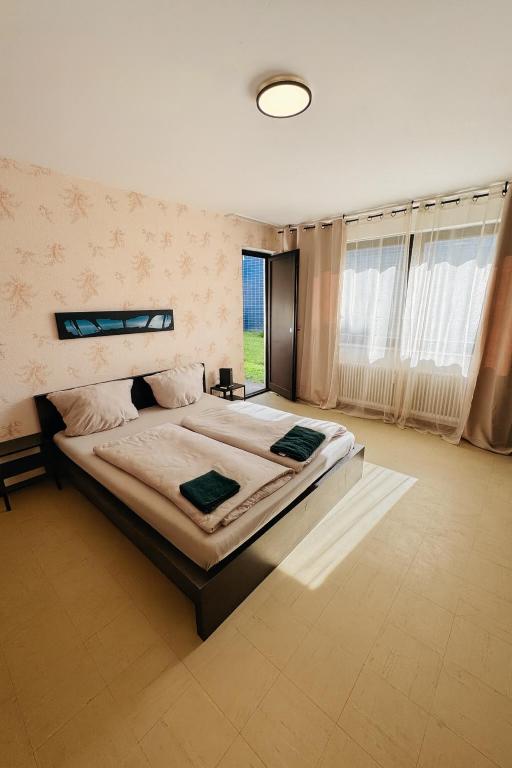 a large bedroom with a large bed and a window at Helle 2-Zimmer Erdgeschosswohnung mit Terrasse in Koblenz