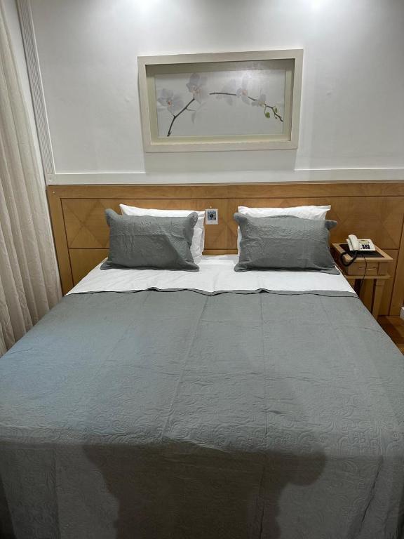 a large bed with two pillows in a bedroom at Hotel UH2107 Inter Jardins in São Paulo