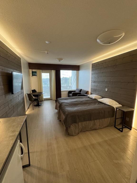 a large bedroom with a large bed and a desk at Hotelli Terme, huone 617 in Ikaalinen