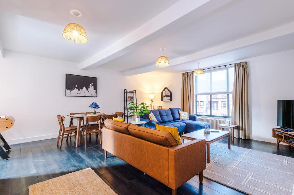 a living room with a couch and a table at Stunning 3BR Townhouse, Terrace, Games, Free Parking in Manchester