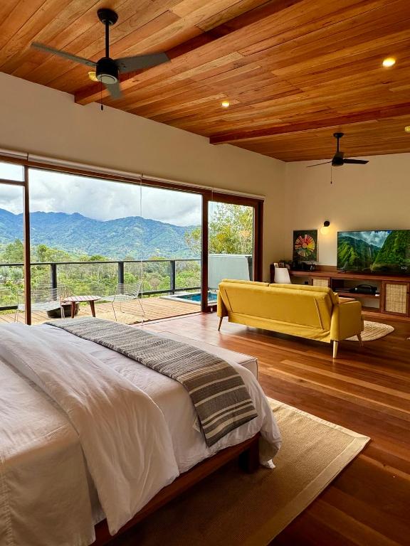 a bedroom with a large bed and a large window at Finca Panda in Boquete
