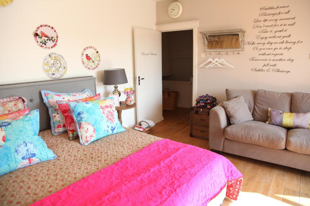 a bedroom with a pink bed and a couch at Bubbles & Bed in Bilthoven