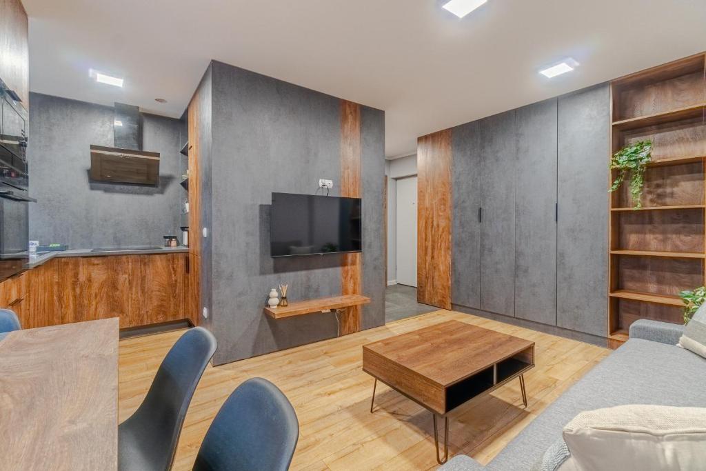 a living room with a table and a tv at Apartament Lubliniec Centrum, PW Invest Home in Lubliniec